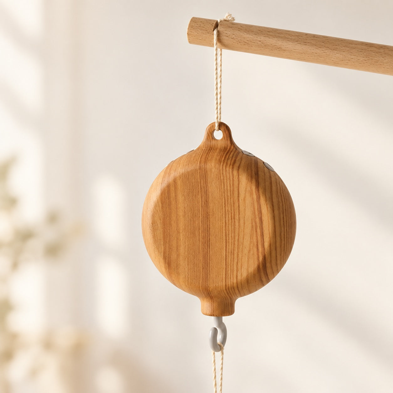 Wooden hanging music box shown on a natural wood arm