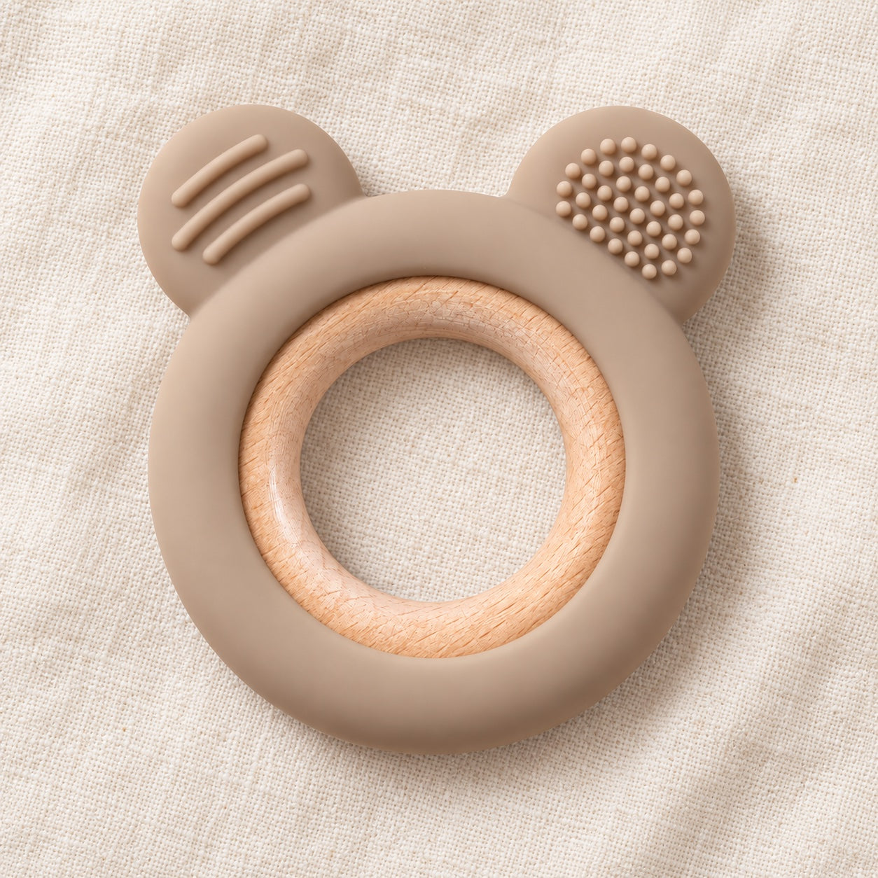 Taupe bear-ear teether with wooden ring on cream linen